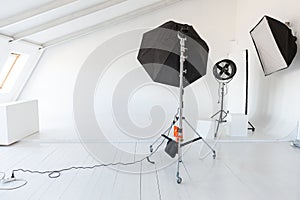 Empty photo studio with lighting equipment. Photographer workplace interior with professional tool set gear. Flash light