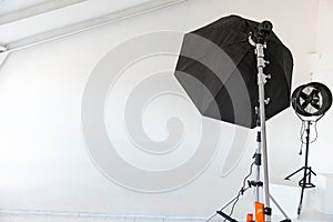 Empty photo studio with lighting equipment. Photographer workplace interior with professional tool set gear. Flash light