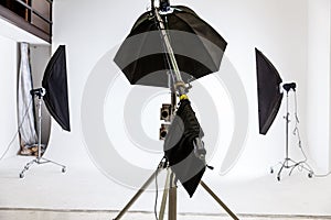 Empty photo studio with lighting equipment. Photographer workplace interior with professional tool set gear. Flash light