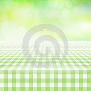 Empty picnic gingham tablecloth, green background