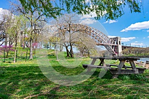 Empty Picnic Table during Spring along the East River on Randalls and Wards Islands of New York City with the Hell Gate Bridge in