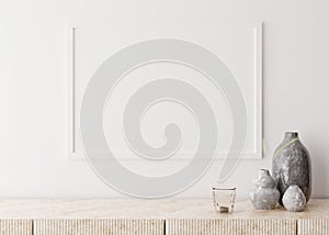 Empty picture frame on white wall in modern living room. Mock up interior in minimalist, scandinavian style. Free space