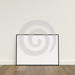 Empty picture frame on wooden floor leaning against wall. Blank poster frame standing on wooden floor. Blank poster frame mockup.