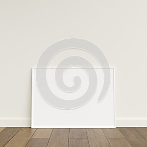 Empty picture frame on wooden floor leaning against wall. Blank poster frame standing on wooden floor. Blank poster frame mockup.