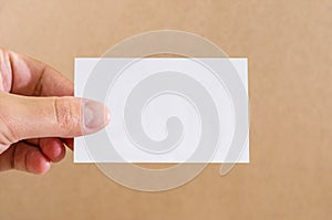 Empty piece of paper in a female hand. White card in a hand. Close-up. Copy space. Place for text.