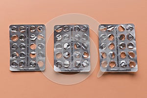 Empty pill blister on brown background, supplement concept