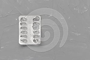 Empty pill blister on gray background, supplement concept