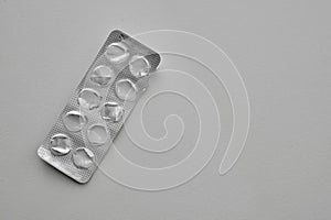 Empty pills blister pack on a gray background with copy space