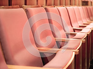 Empty pink chairs in conference hall or theater.