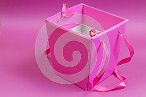 Empty pink gift box on a pink background.