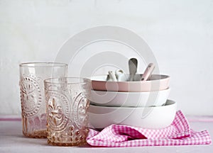 Empty pink and white bowls and kitchen utensils