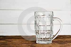 Empty pint lager on wooden table.