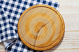 Empty pizza board with napkin on white stone table, top view, copy space. Wooden cutting board over white concrete background mock