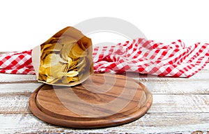 Empty pizza board and tablecloth and potato chips pack on table isolated on white background copy space