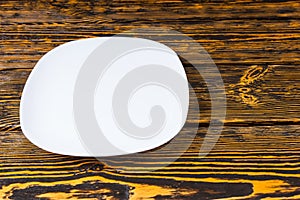 Empty plain white plate on a wood background