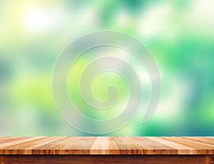 Empty plank brown wood table top with blur green tree background