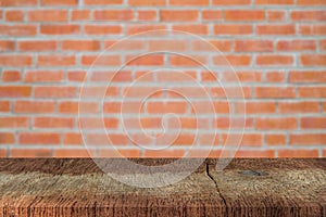 Empty plank brown wood table top with blur red brick wall  texture background.