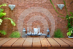 Empty plank brown wood table top with blur red brick wall  texture background.