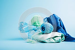 Empty plastic bottle and various fabrics made of recycled polyester fiber synthetic fabric on a blue background