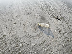 An empty plastic bottle was left on the beach