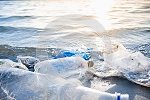 Empty plastic bottles on the beach, seashore and water pollution concept.