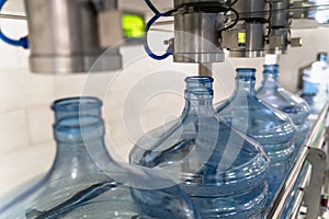 Empty plastic bottles or gallons on conveyor belt machinery equipment for checking plastic integrity and hardness in