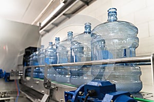 Empty plastic bottles or gallons on conveyor belt machinery equipment in pure water production factory