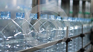 Empty plastic bottles with a volume of 5 liters move along the conveyor in the workshop of the mineral water bottling