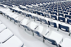 Empty plastic chairs covered in snow