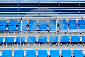 Empty plastic chairs in the stands of the stadium. Many empty seats for spectators in the stands.