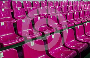 Empty plastic chairs in the stands of the stadium. Many empty seats for spectators in the stands. Empty plastic chairs seats for