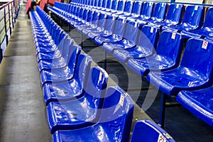 Empty plastic chairs in the stands of the stadium. Many empty seats for spectators in the stands. Empty plastic chairs seats for