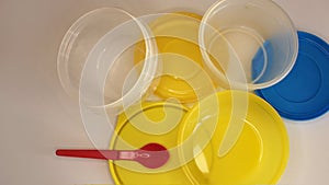 Empty plastic dinnerware on white table background