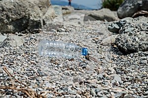 Empty plastic garbage dumped on pebble stones