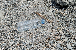 Empty plastic garbage dumped on pebble stones