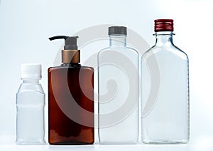 Empty plastic and glass bottle with cap and pump with black label isolated on white background. Pharmaceutical products bottle