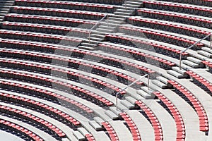 Empty plastic red seats on football stadium or amphitheater