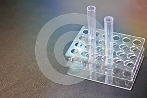 Empty plastic test tube Two tubes on the holder Black leather tabletop background.Glass test tube in science laboratory, black
