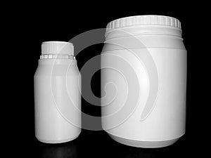 Empty plastic white bottles on a dark background.