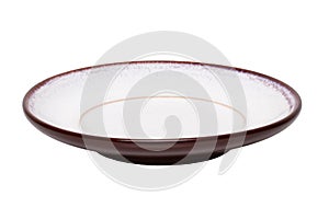Empty plate background. A decorative brown and white plate isolated on a white background. Kitchen ware