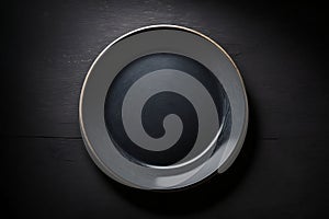 Empty plate on black table, shabby dark background. Top view. Food template, copy space. Flat design, mockup. Layout, frame. Place