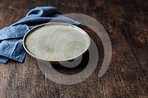 Empty plate and blue towel over wooden table