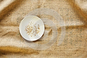 Empty plate with bread crumbs on raw fabric