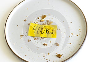 empty plate with crumbs and calories label. Concept counting kcal, food control, Intuitive eating, breakfast.