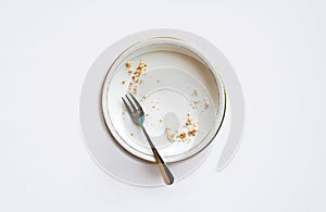 Empty plate with crumbs after eating on a white background. T