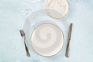 An empty plate with cutlery and a wineglass, place setting at a restaurant