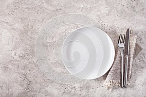 Empty plate fork knife on concrete background