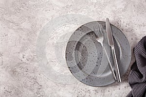 Empty plate fork knife on concrete background