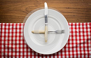 Empty plate with fork and knife on tablecloth over