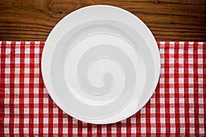 Empty plate with fork and knife on tablecloth over